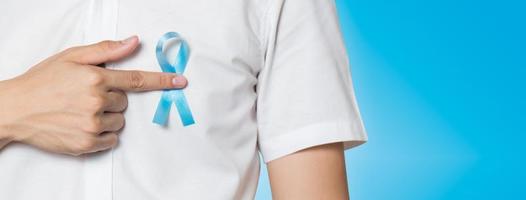 Close up of male hand pointing to light blue ribbon for prostate cancer photo