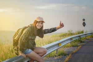 mujer haciendo autostop en carretera foto