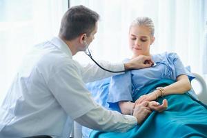 doctor hombre tomando el pulso del paciente femenino foto