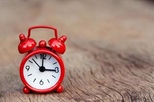 Red alarm clock on wood background  photo