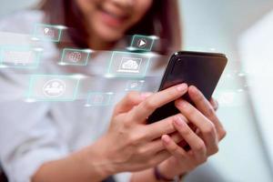 Woman holding smartphone with social media icons displayed  photo