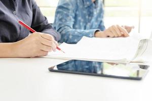 Two people studying together with phone in foreground  photo