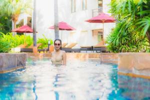 Retrato hermosa mujer asiática joven relajarse alrededor de la piscina en el hotel resort foto