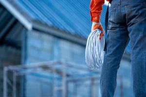 trabajador sujetando la cuerda frente al sitio de construcción foto