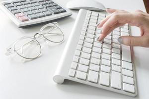 Close-up of woman typing on keyboard photo