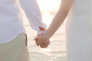 Couple holding hands at sunset photo