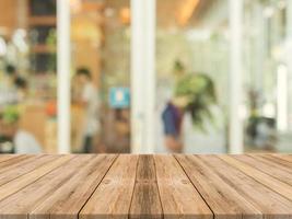 Mesa de madera delante del fondo borroso de la cafetería foto