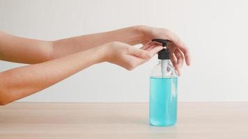 Young Asian woman using alcohol gel hand sanitizer. photo