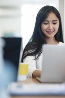 joven asiática trabajando desde casa foto