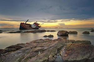 Shipwrecked boat at sunset photo