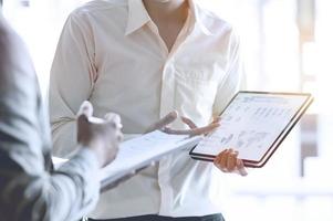 Two businessmen use tablet to discuss business plan  photo