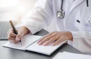 Female doctor writing  on notebook  photo