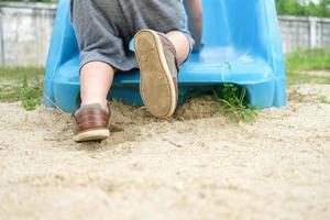 Little kid climbing up playground slide photo