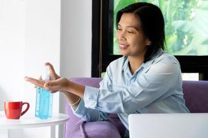 Woman using hand sanitizer photo