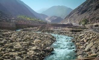 río que fluye a lo largo de la cordillera de karakoram en verano foto