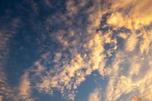 Yellow and orange clouds and blue sky photo