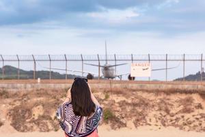 Woman photographing airplane photo