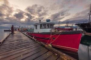 barco rojo y blanco en el muelle bajo cielo nublado foto