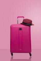 Pink suitcase with hat photo