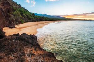 montaña verde y marrón al lado del cuerpo de agua foto