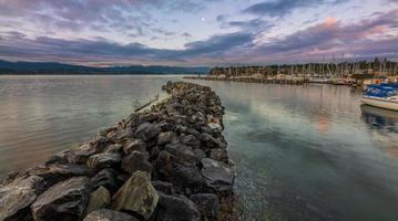 Gray rocks near body of water under blue sky photo