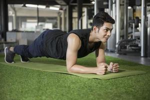 Man in yoga plank pose in gym photo