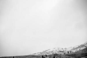 Grayscale photo of mountain and cloudy sky