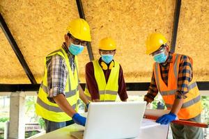 Hombres con mascarillas protectoras con laptop foto