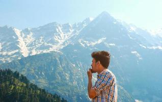 Man in plaid looking at mountains and trees photo