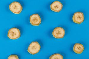 Unpeeled banana slices on blue background photo