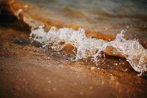 primer plano de las olas en la playa foto