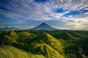 Scenic view of mountain and grass covered hills photo