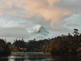 Snowy mountain peak covered by clouds photo