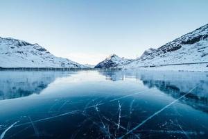 Frozen river with snow covered mountains photo