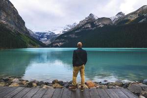 Man in blue standing at the Canadian Rockies photo