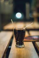 Drink with two straws on wood table photo