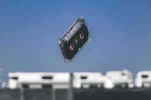 Black cassette tape in mid-air