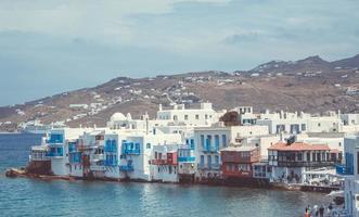 Waterfront homes next to mountain photo