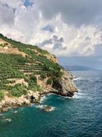 Grassy cliff over blue ocean waters photo