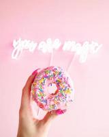 Woman holding donut with sprinkles photo