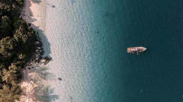 Aerial view of boat in ocean near a beach photo