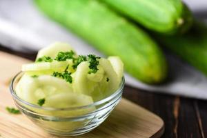 Sliced cucumbers in bowl with melons photo