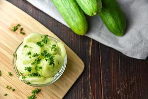 Sliced cucumbers in bowl with melons photo