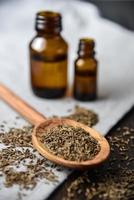 Cumin seeds and oil in bottles photo