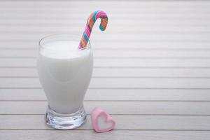 Glass of milkshake with candy cane photo