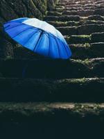 Blue umbrella on black stairs photo