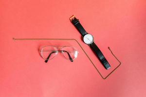 Gold necklace, glasses, and watch photo