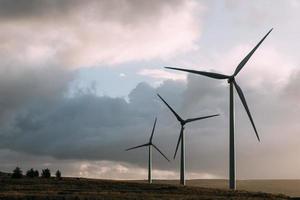 Wind turbines in field with cloudy sky photo