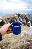 mano sosteniendo café azul y taza foto