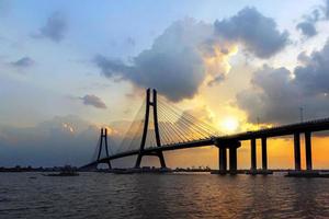 puente sobre el cuerpo de agua durante el atardecer foto